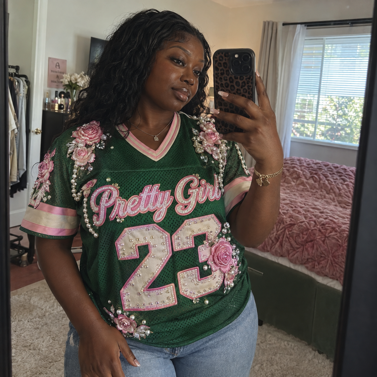 Black woman taking a mirror selfie in a green embellished Pretty Girl football jersey